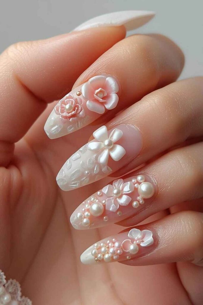 Sculpted floral 3D acrylic nails featuring textured bows, flowers, pearls, and detailed nail art.