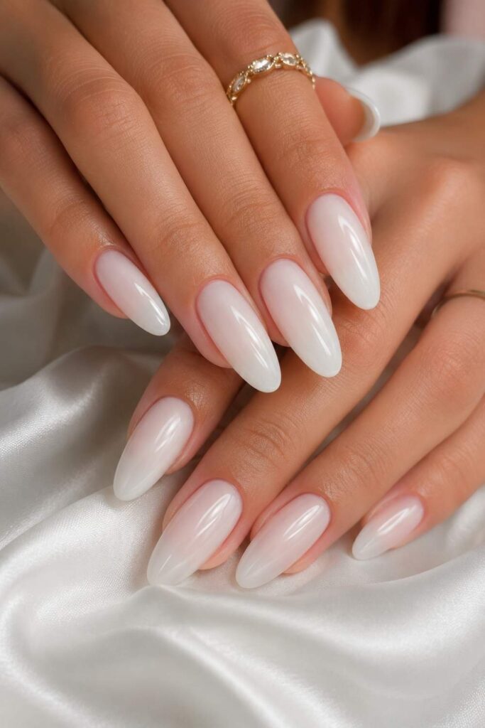 Semi-sheer milky white acrylic nails with glossy finish and subtle pink undertones.