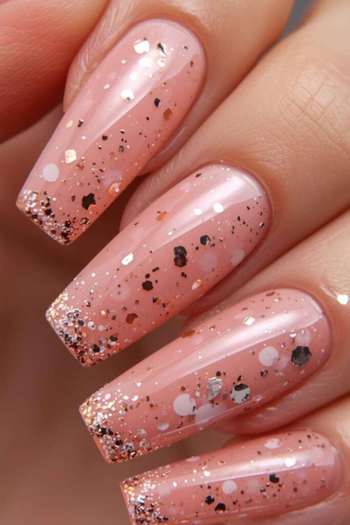 Blush pink acrylic nails decorated with gold foil accents and luxury chrome detailing.