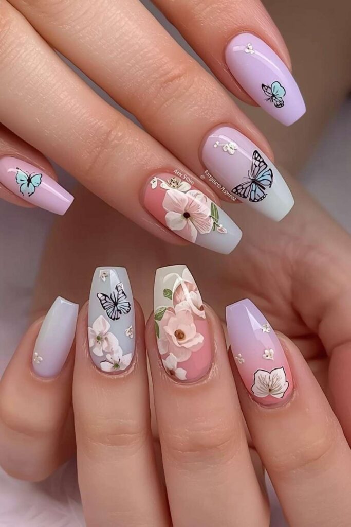 Floral pastel acrylic nails featuring butterflies, soft spring colors, and glossy luxury manicure styling.