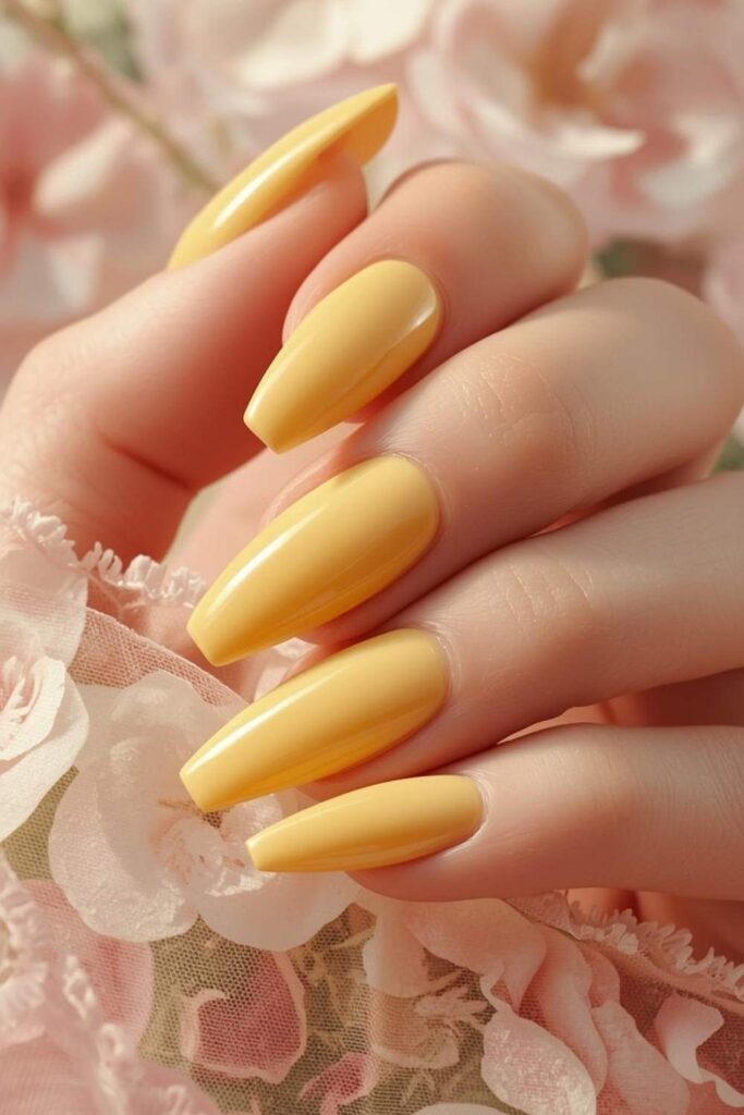 Butter yellow acrylic nails with glossy spring-inspired manicure and fresh seasonal styling.
