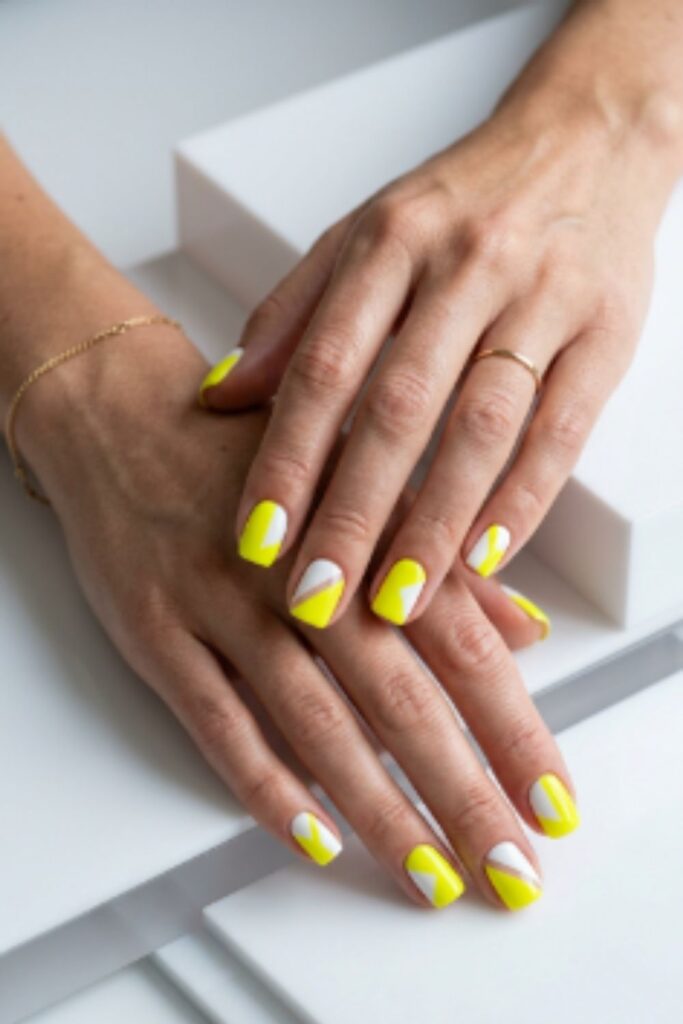 Acid yellow geometric nails with modern negative space blocks and glossy square gel manicure.