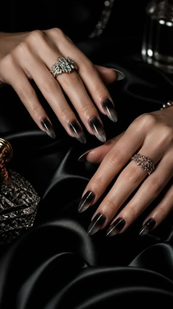 Glossy black aura gel nails with smoky gradient effect on elegant almond-shaped nails.