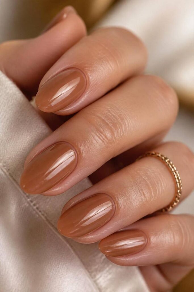 Classy short acrylic nails with glazed caramel polish and high-shine glossy finish for a sophisticated everyday manicure.