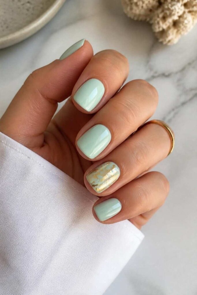 Classy acrylic nails short in soft mint featuring a luxurious gold foil accent nail.