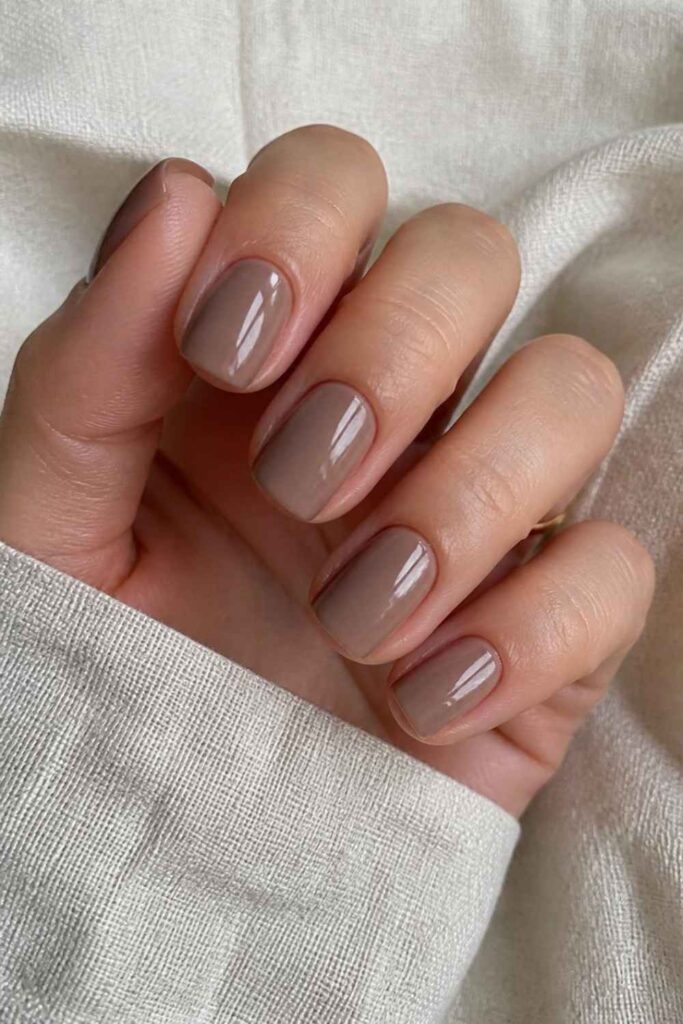 Classy short acrylic nails in warm taupe square shape with glossy top coat and elegant salon-quality finish.