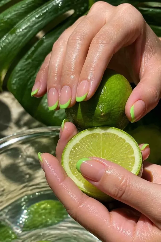 Nude gel nails finished with vibrant neon green French tips for a fresh summer look.