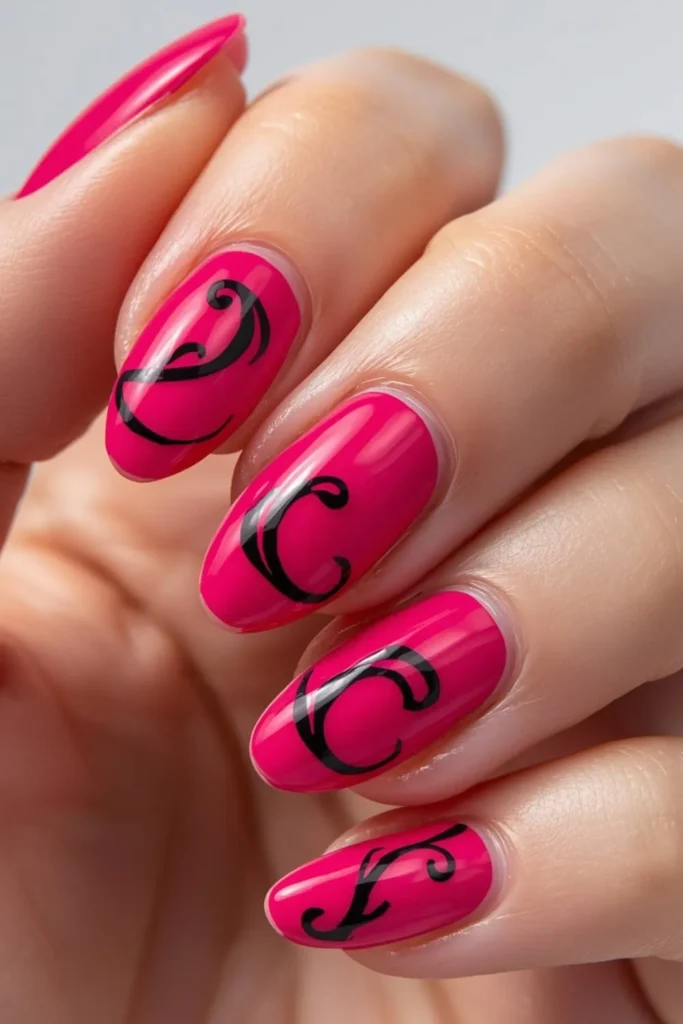 Vibrant hot pink short nails with bold black swirl nail art creating a modern graphic manicure on glossy natural nails.