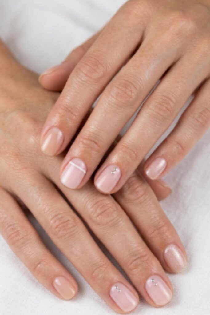 Minimalist Short Nail Designs featuring glossy nude polish, soft pink nails, delicate stripes, metallic dots, and clean everyday manicures.