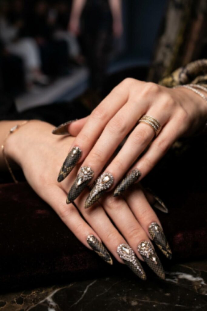 Dramatic stiletto Long Nail Designs featuring matte snakeskin texture and sparkling rhinestone embellishments
