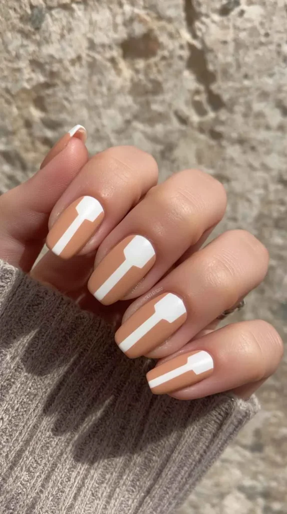 Short square nails featuring geometric soft clay and warm white split nail art on a minimalist nude manicure.